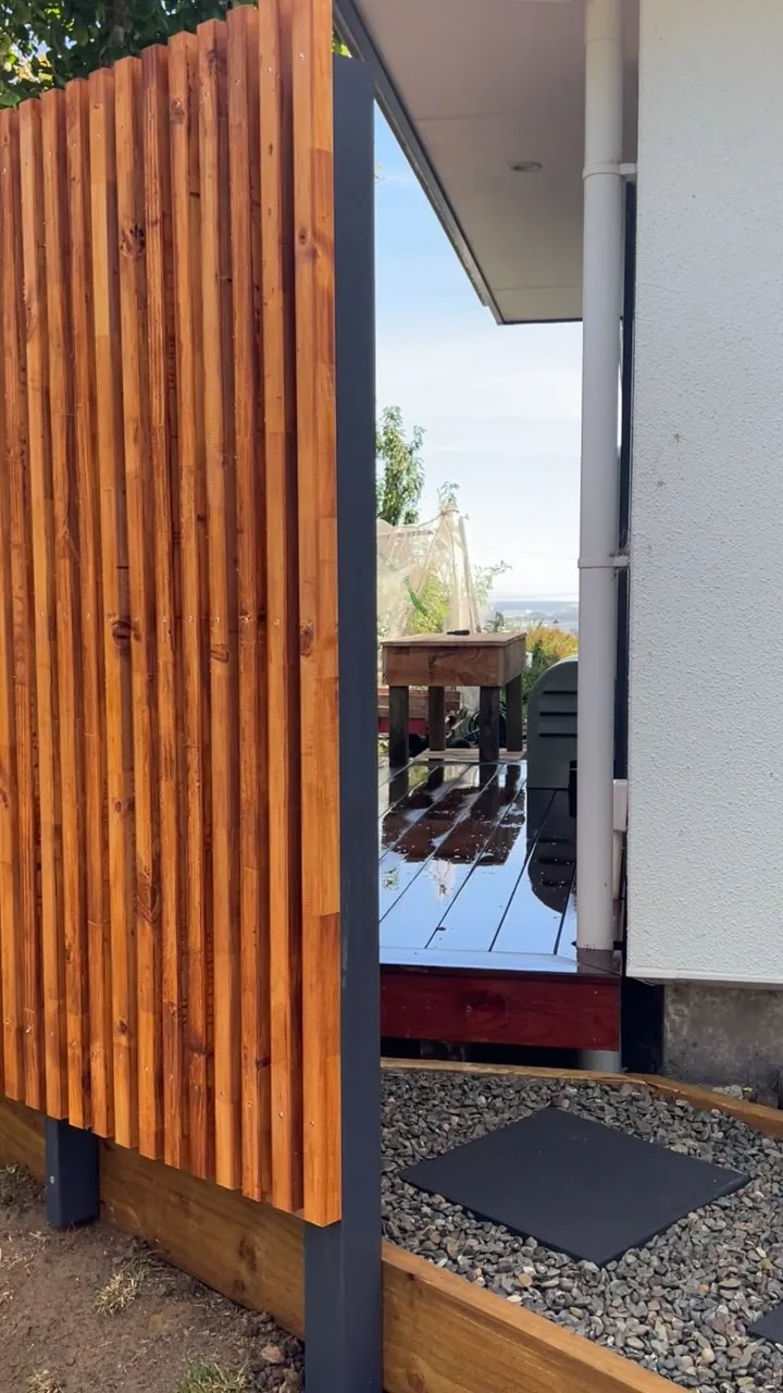 Cedar slat privacy screen beside a dark deck