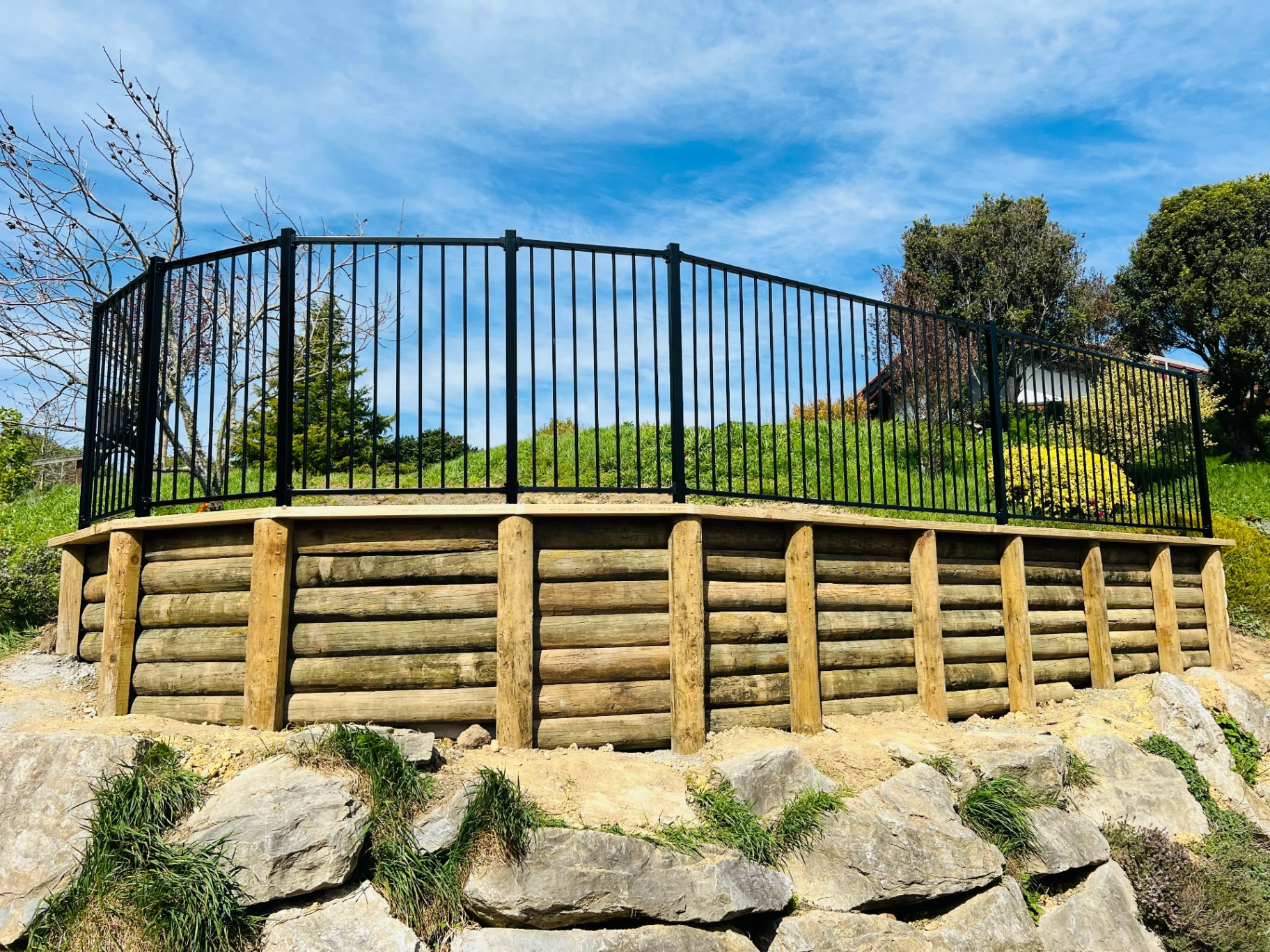 Pole retaining wall with steel balustrade detail