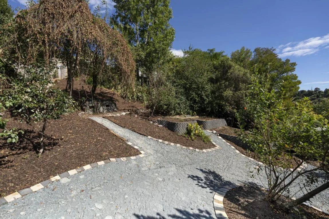 Finished stone path with timber retaining alongside a Nelson garden