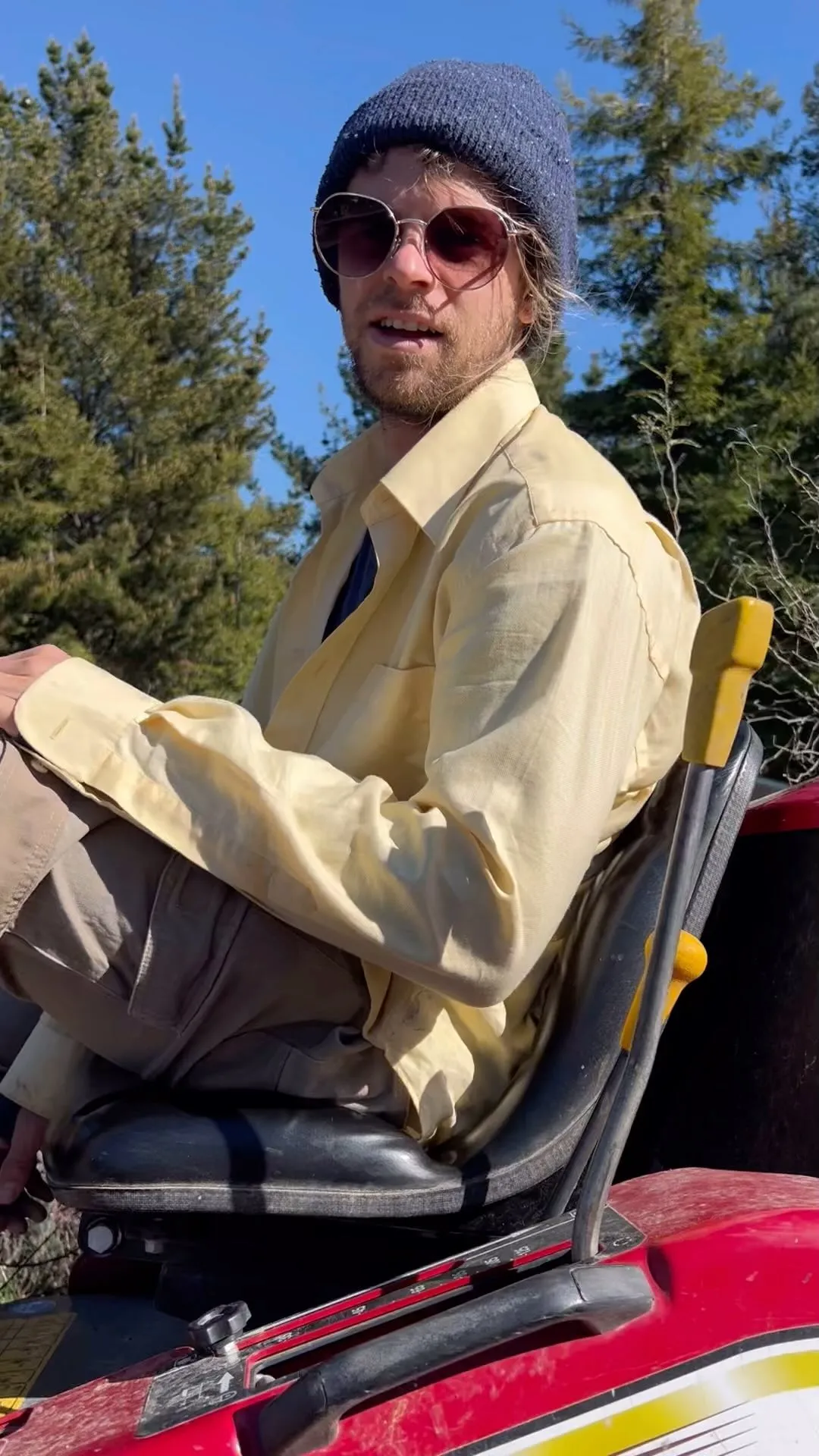 Crew member on a ride-on mower in the sunshine